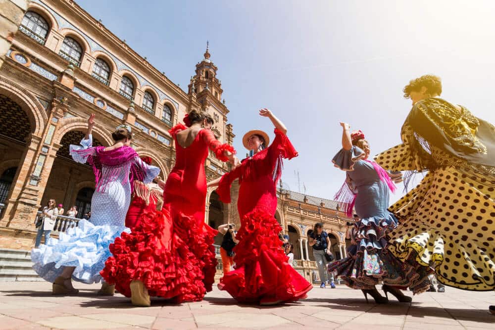 sevillanas bailando flamenco con sus vestidos típicos